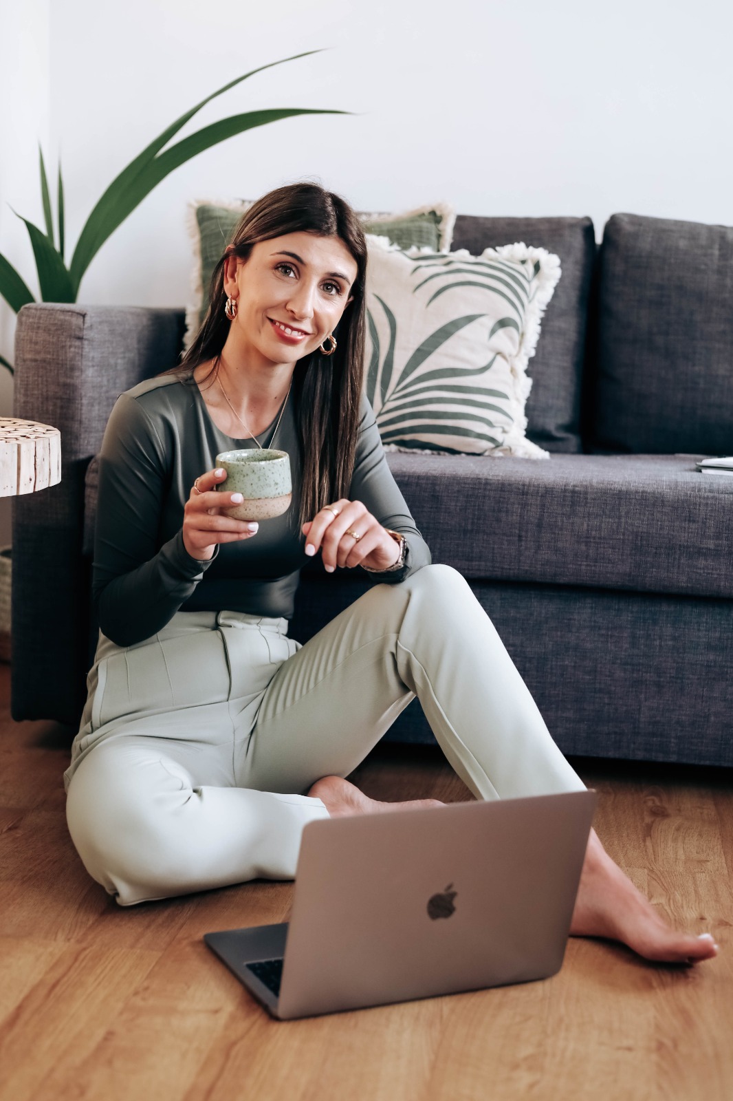 Nutricionista sentada no chão com laptop